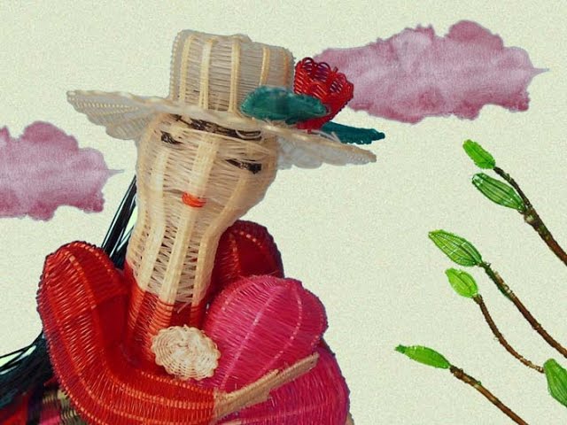 una señorita muy señoreada lleva sombrero verde y blusa colorada